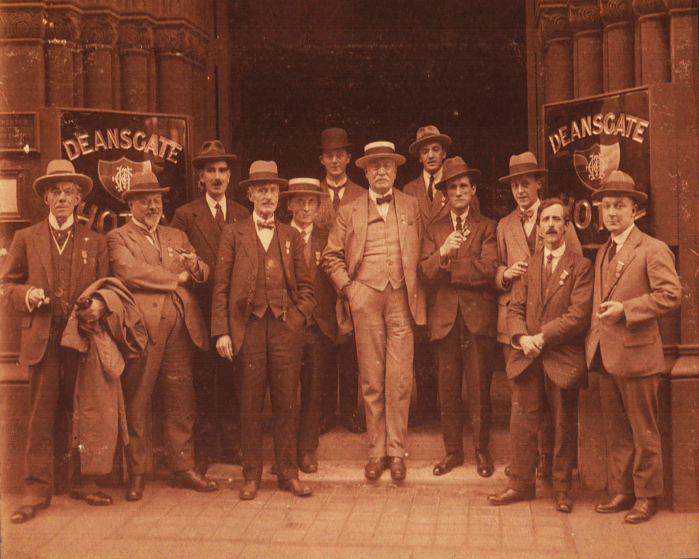 A sepia photograph of some of the very first members of The Order of The Magi, stood outside the Deansgate Hotel in Manchester