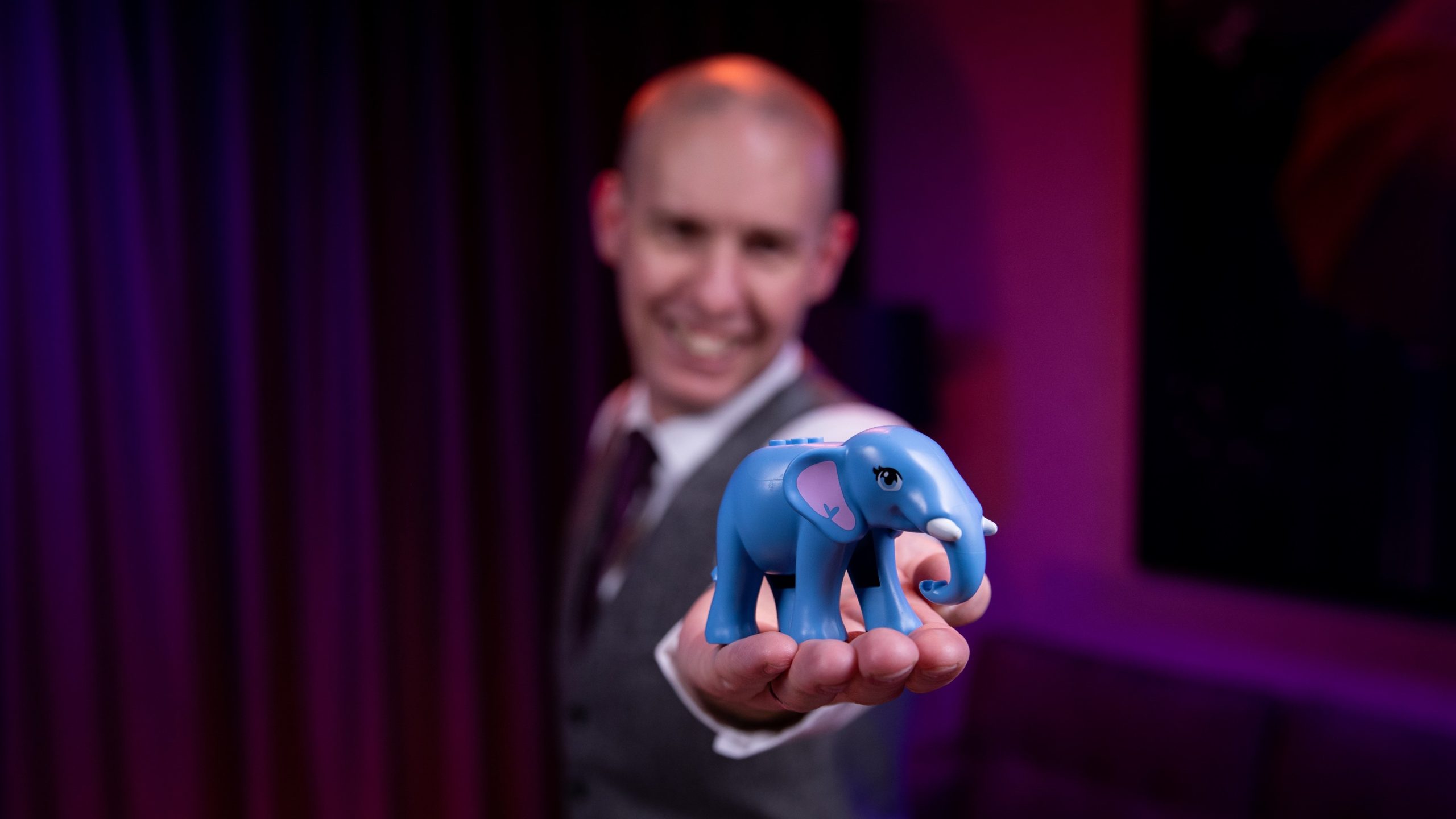 Dr Matt Pritchard Optical Illusion Lecture in Manchester: Dr Matt holds a Blue Toy Elephant - but is everything as it seems, or is there decption at play?